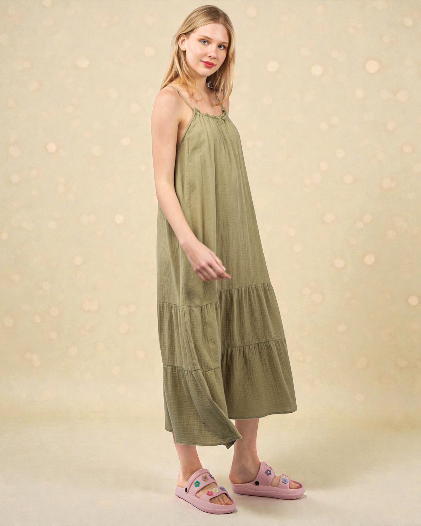 Woman wearing a green dress with a beige background