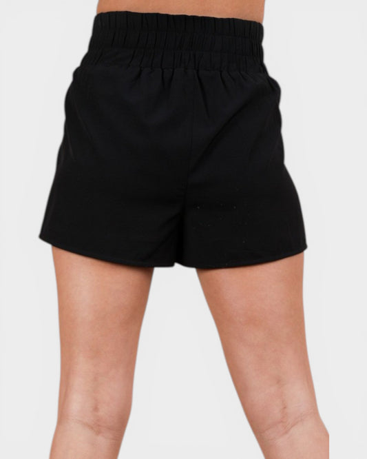 Black shorts worn by a person on a light gray background