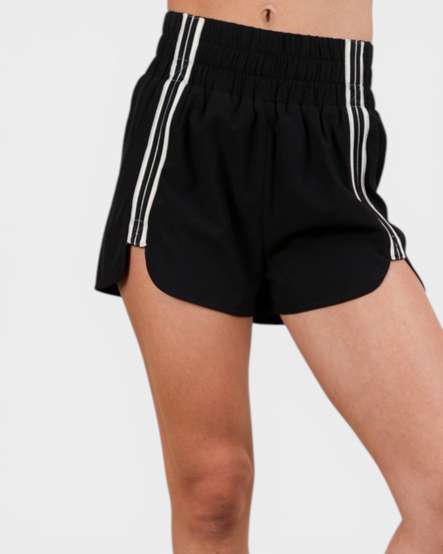 Black shorts with white stripes on a plain background