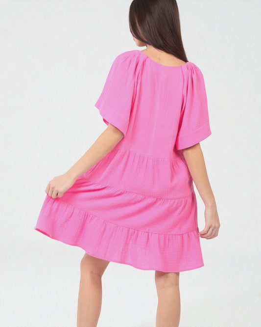 Pink dress worn by a person on a white background