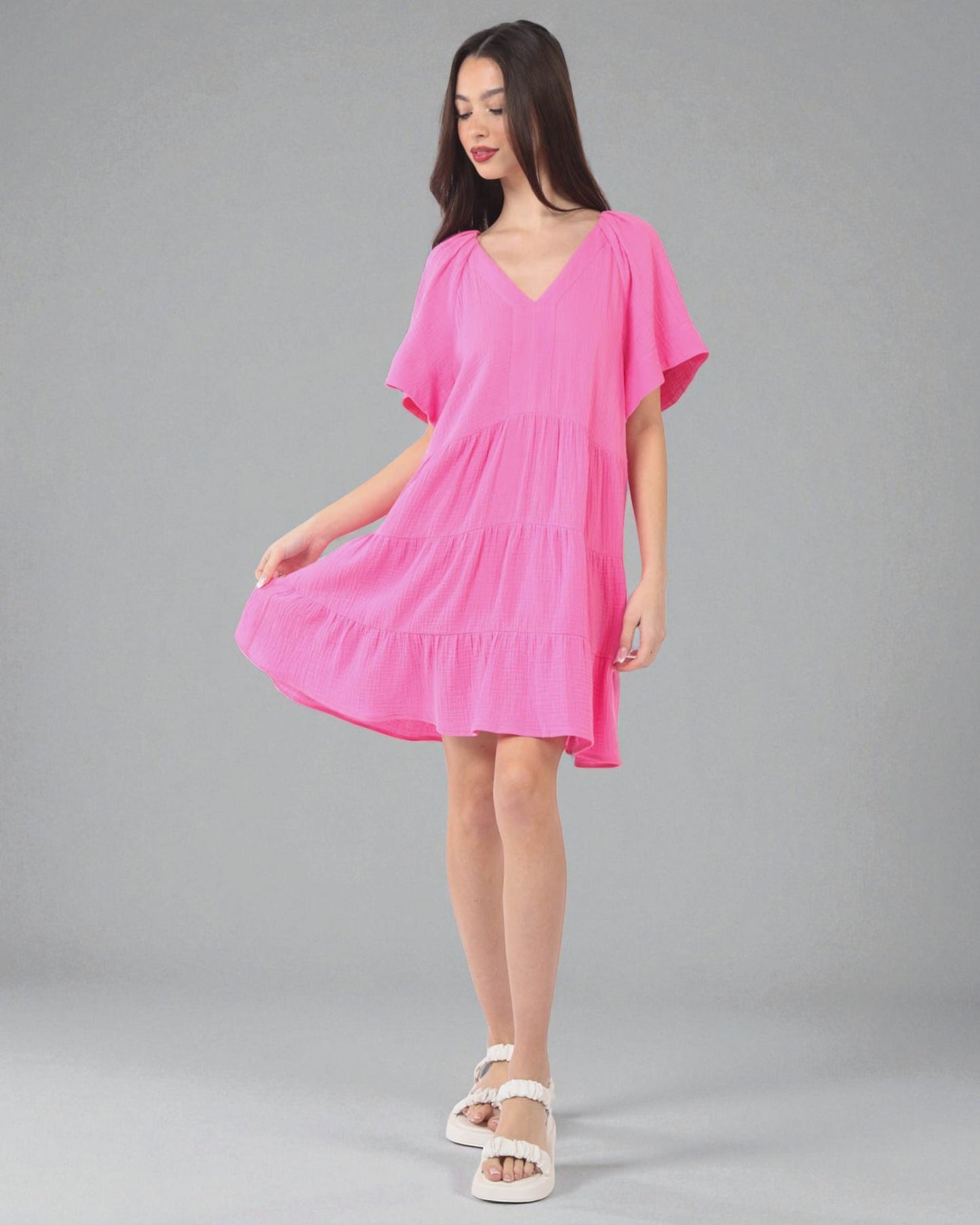 Woman wearing a pink dress on a gray background