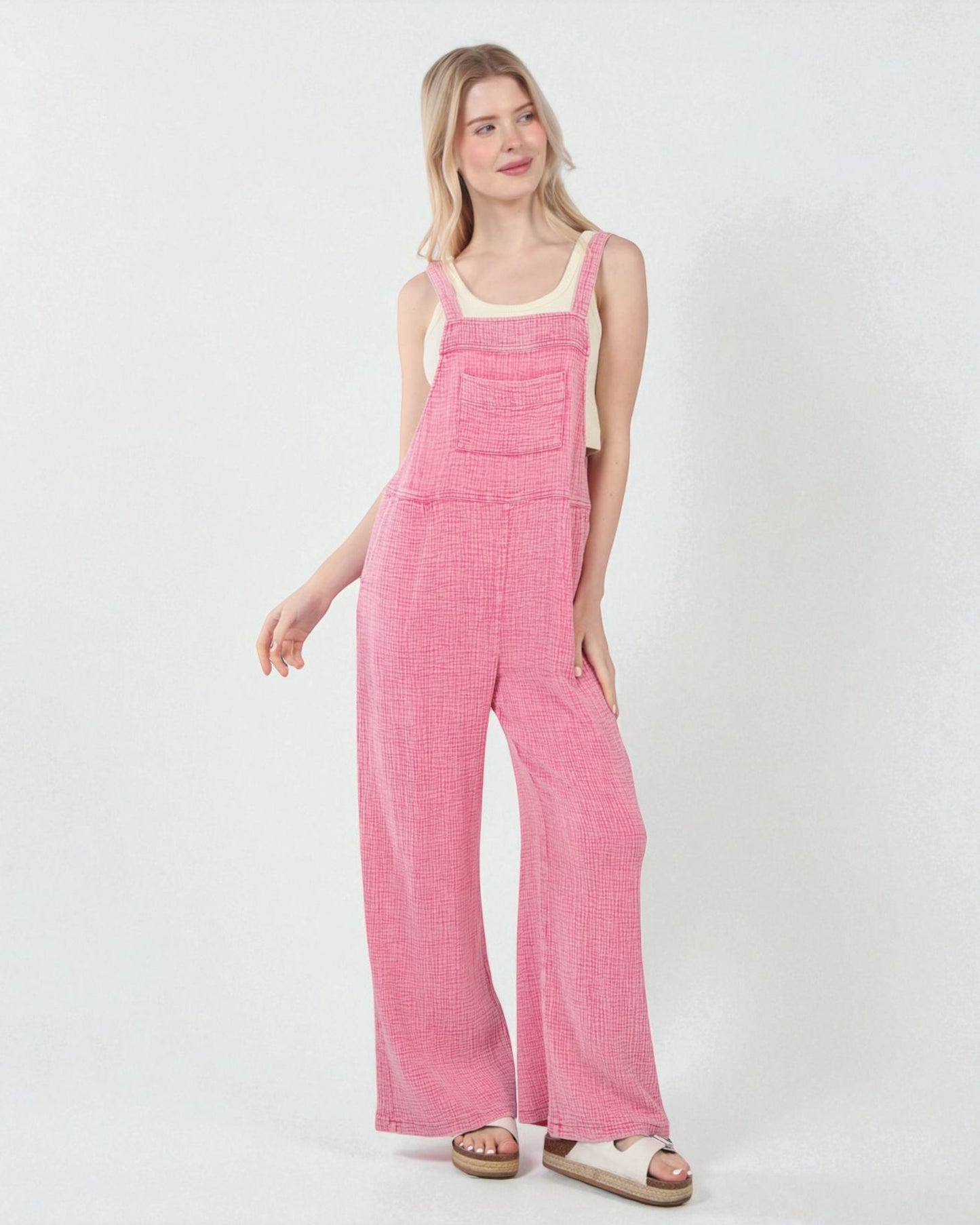 Woman wearing pink checkered overalls on a white background