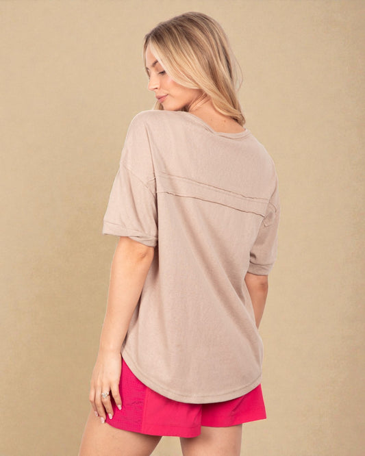 Woman wearing a beige top and pink shorts on a beige background