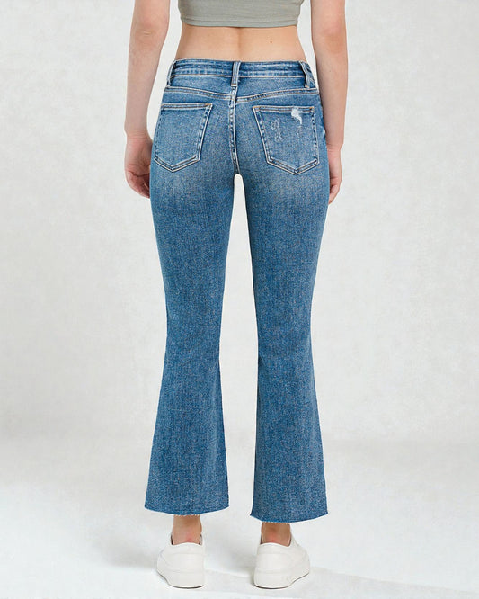 Person wearing blue flared jeans on a white background