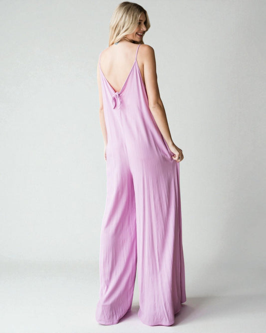 Woman wearing a pink jumpsuit on a plain background