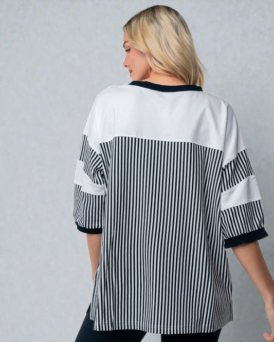 Person wearing a black and white striped shirt against a gray background