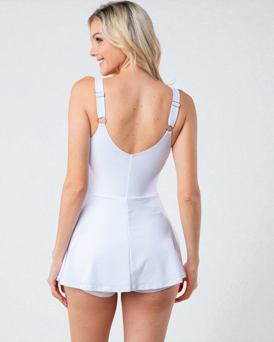 Woman wearing a white romper with thin straps on a light gray background