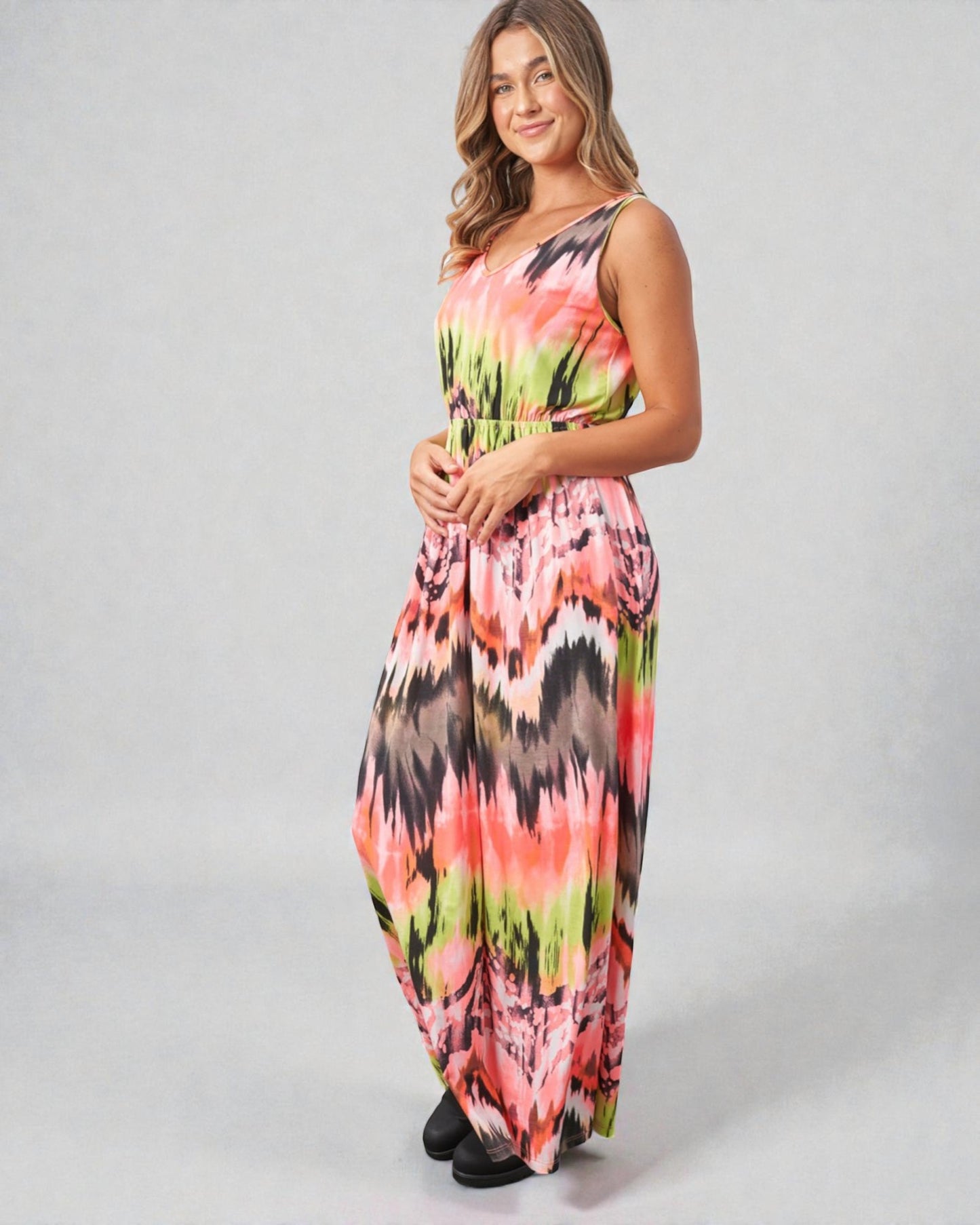 Woman wearing a colorful floral dress on a gray background