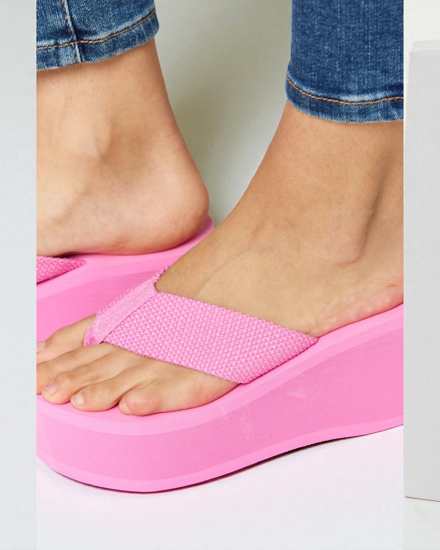 Person wearing a pink sandal on a light background