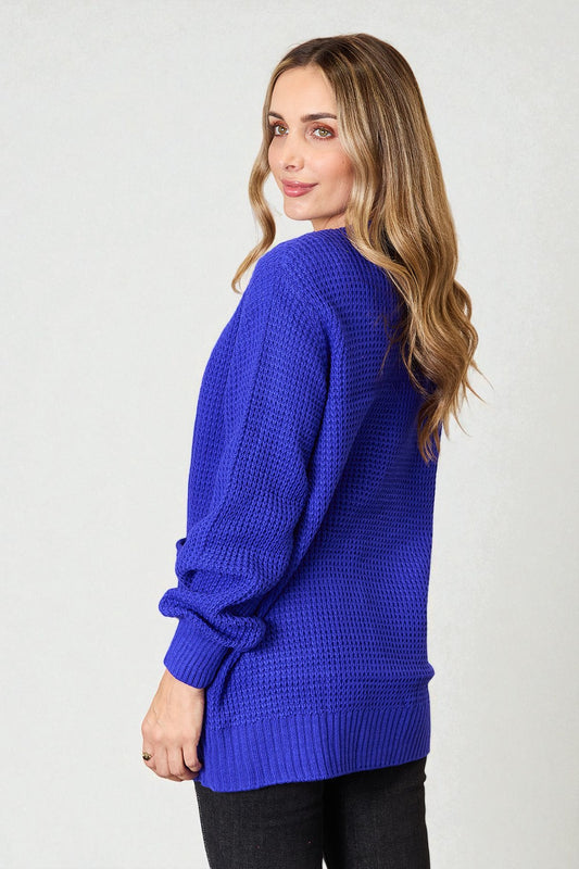 Woman wearing a blue sweater against a white background