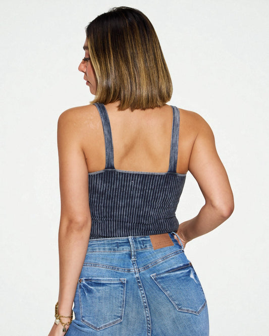 Woman wearing a denim tank top and jeans on a white background