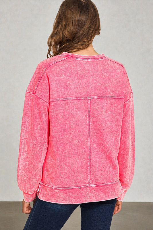 Person wearing a pink sweatshirt with a gray background