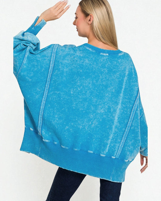 Woman wearing a blue oversized sweater on a white background