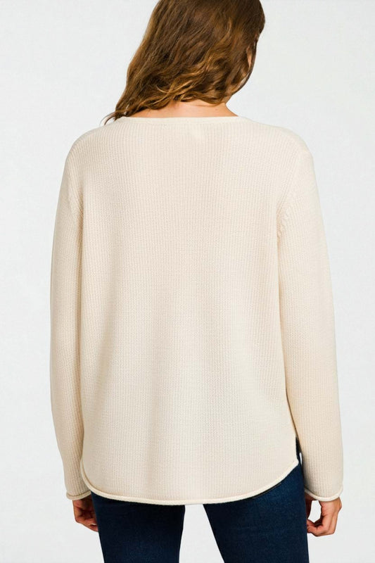 Person wearing a beige sweater on a white background