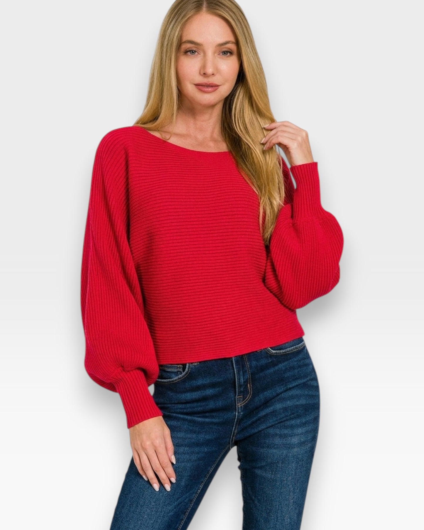 Woman wearing a red sweater and blue jeans on a white background