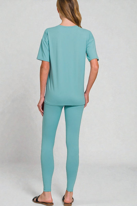 Person wearing a teal outfit on a plain background