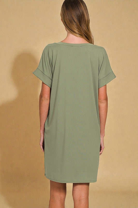Woman wearing a green dress against a beige background