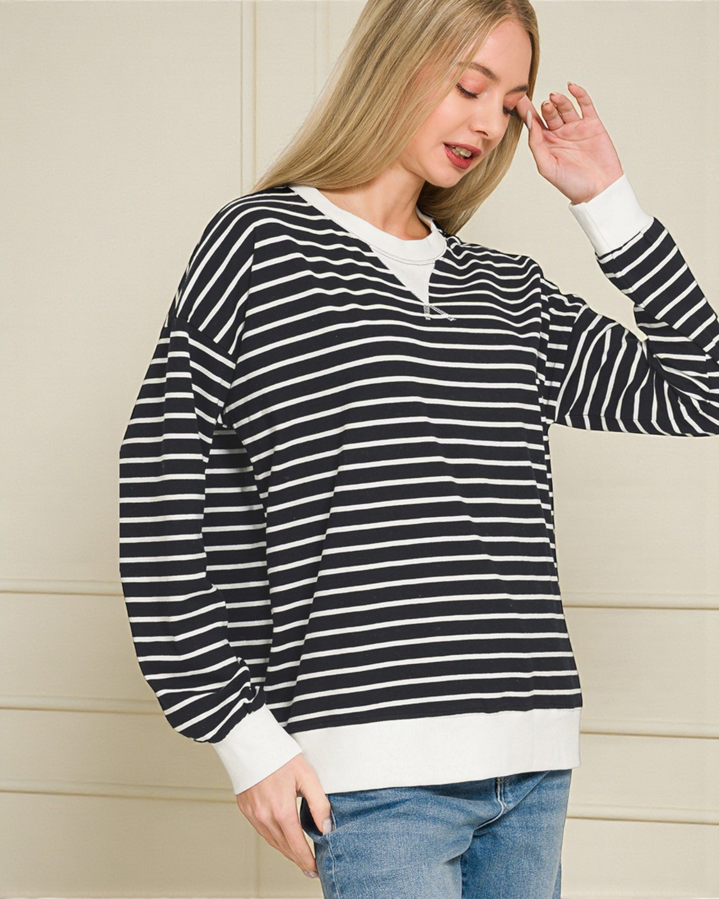 Woman wearing a black and white striped sweater against a neutral background