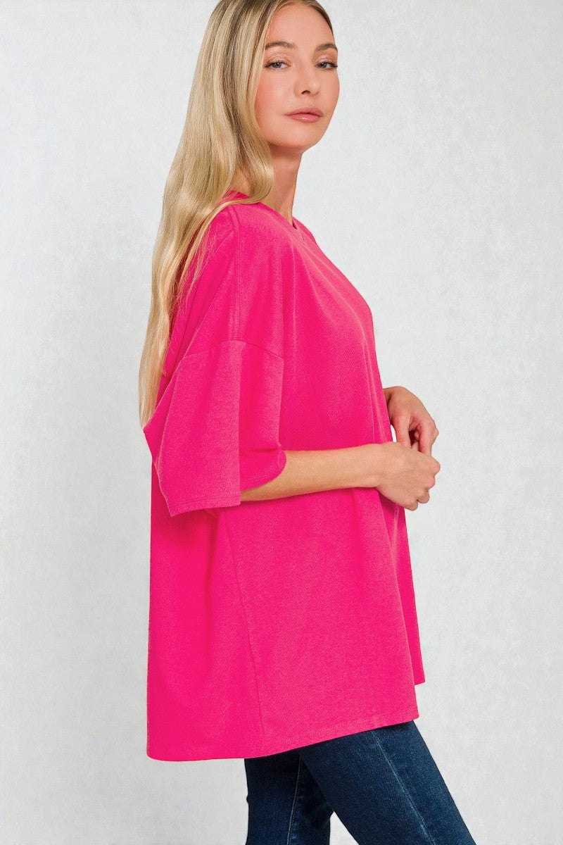 Woman wearing a bright pink top against a white background