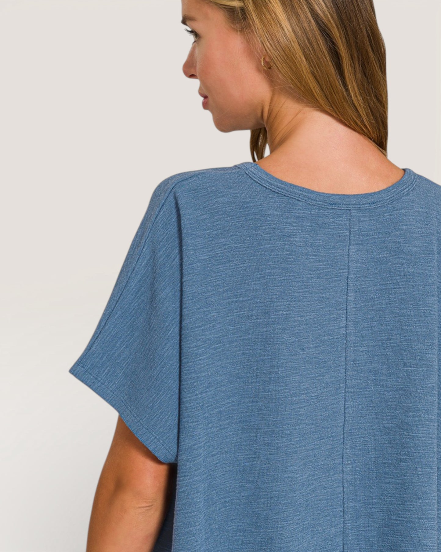 Woman wearing a blue t-shirt against a plain background