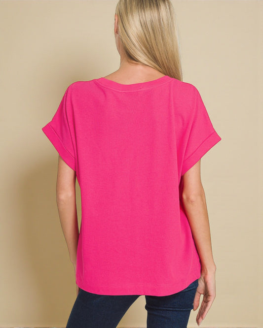 Person wearing a bright pink t-shirt against a beige background