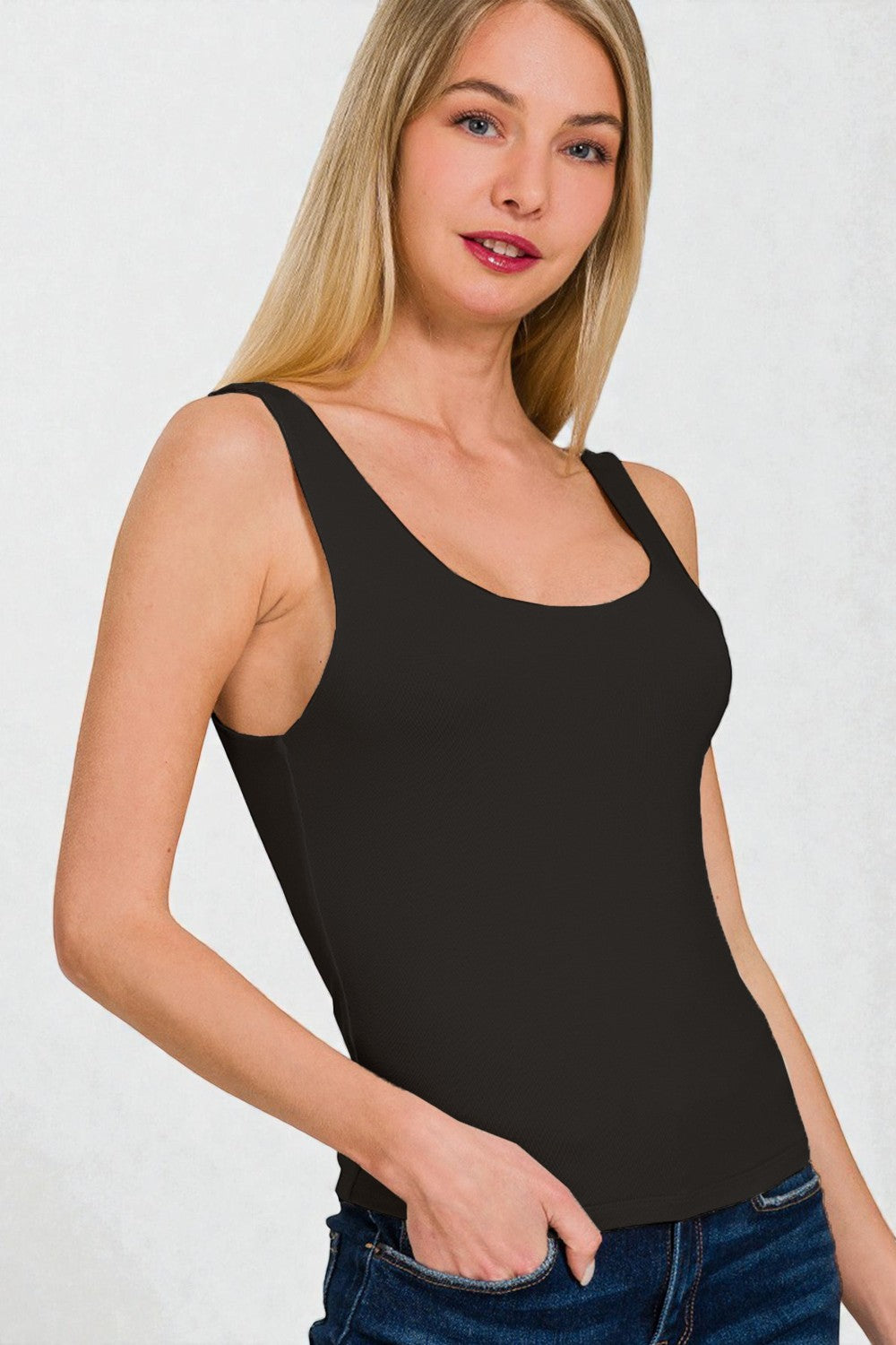 Woman wearing a black tank top against a white background
