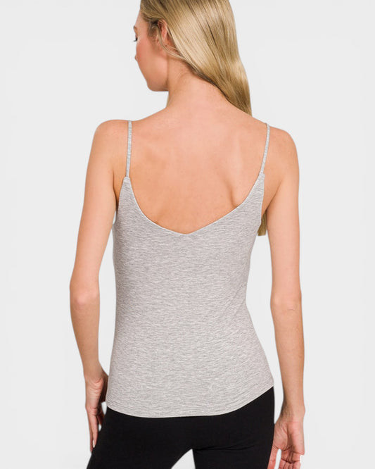 Woman wearing a gray tank top against a plain background