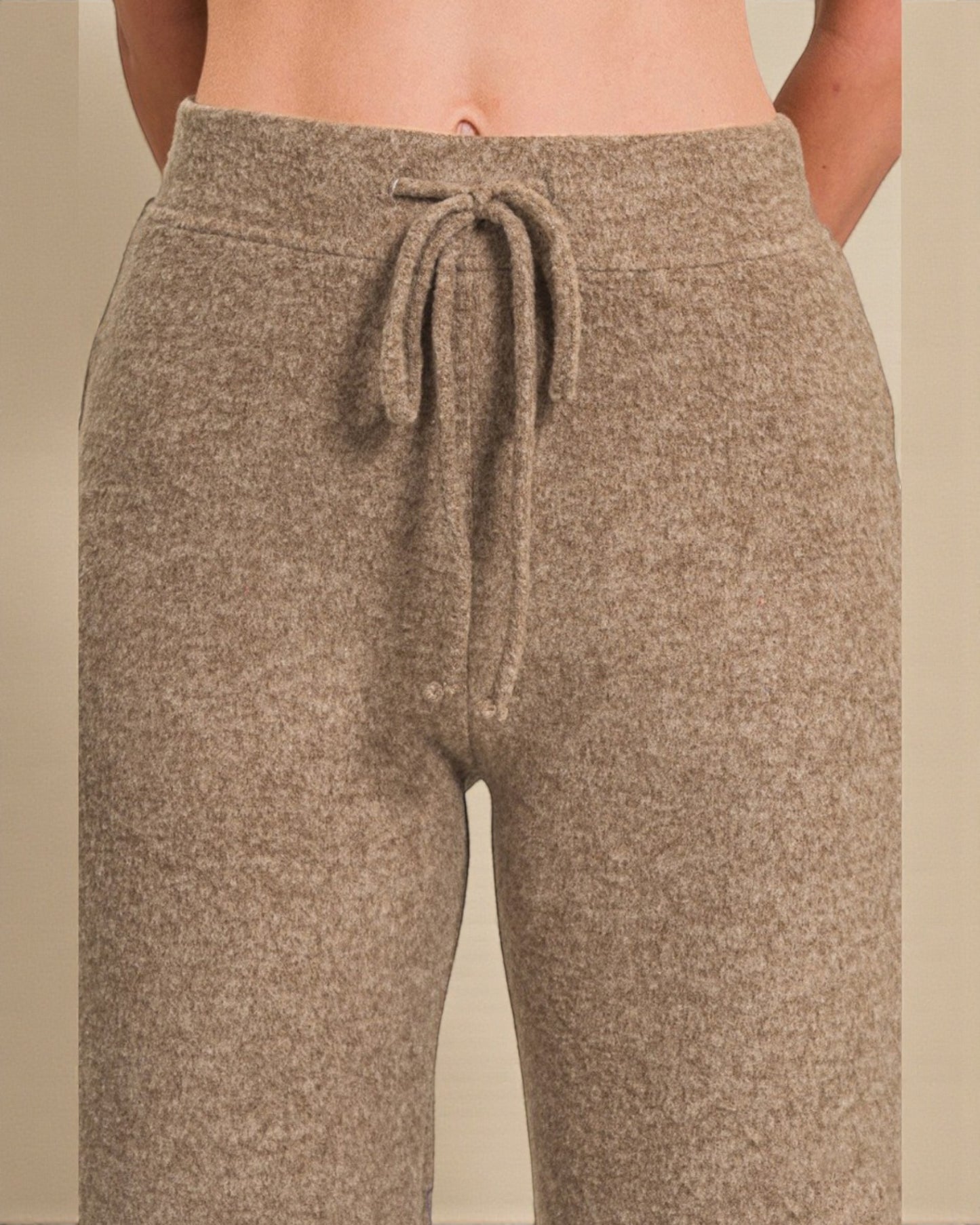 Brown sweatpants with a drawstring on a neutral background