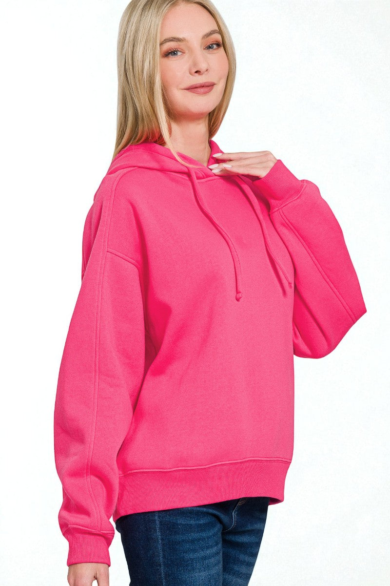 Person wearing a bright pink hoodie on a white background