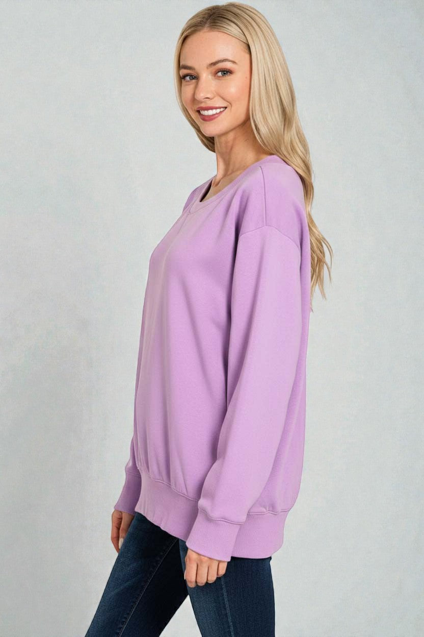 Woman wearing a light purple sweater against a plain background