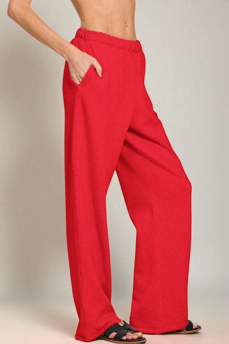 Red wide-leg pants worn by a person on a plain background