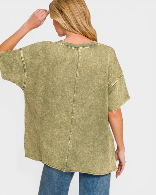 Person wearing a green oversized shirt and blue jeans on a white background