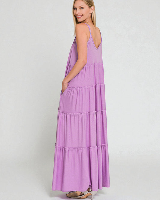 Woman wearing a purple tiered dress on a white background