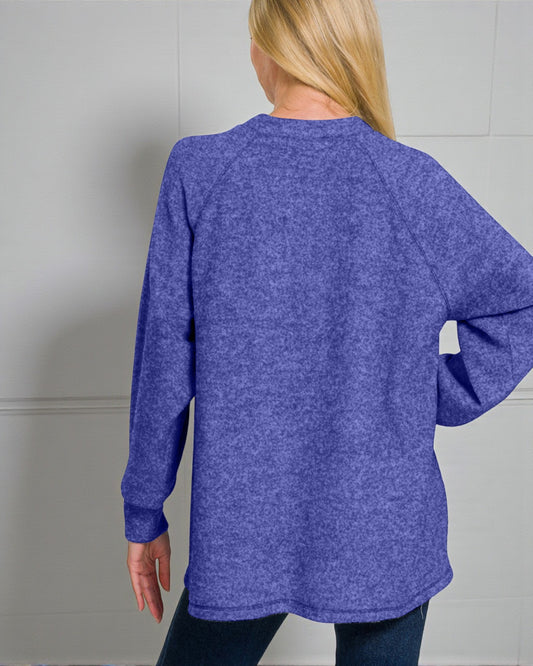 Person wearing a blue sweater against a gray background