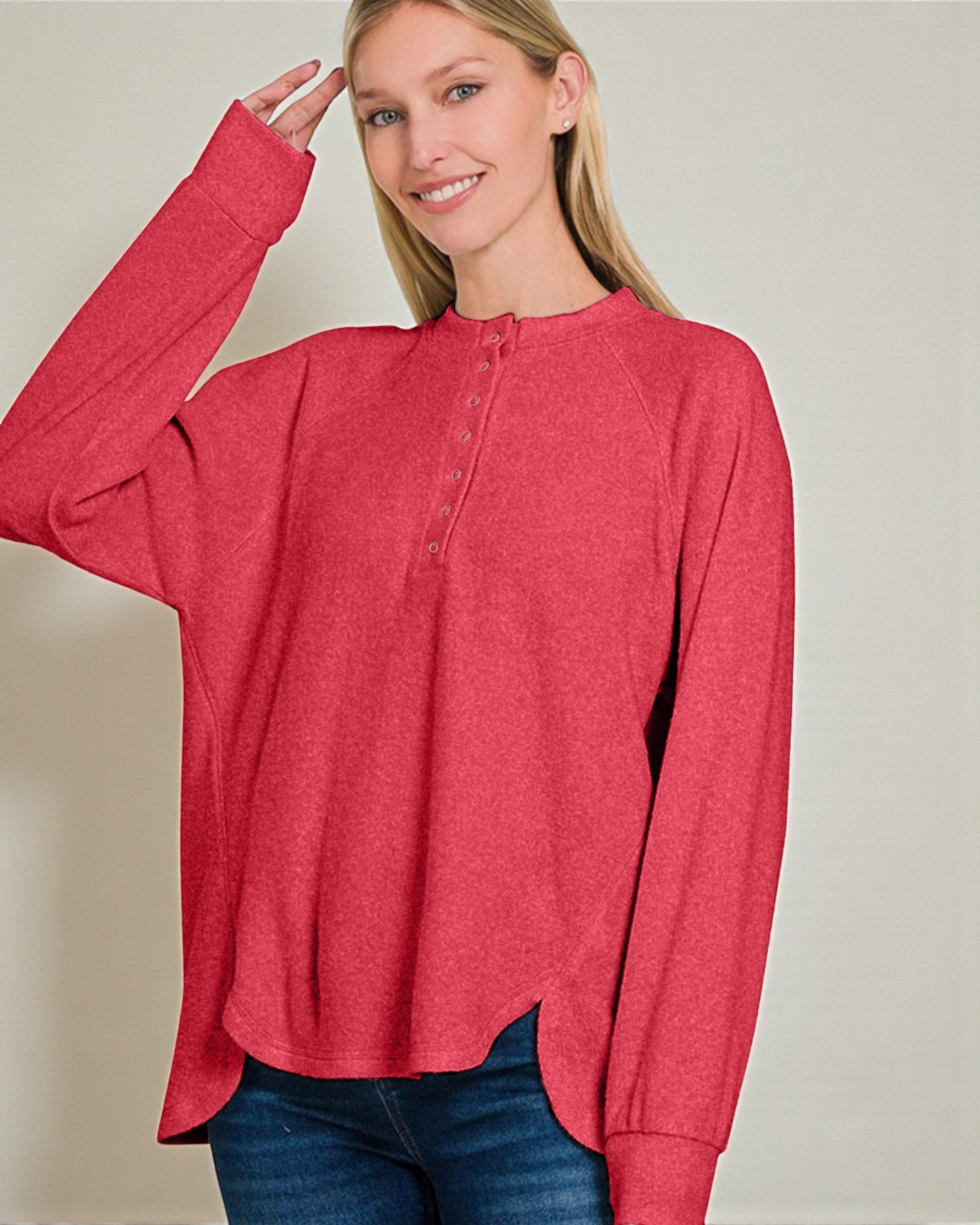 Woman wearing a red long-sleeve shirt against a plain background