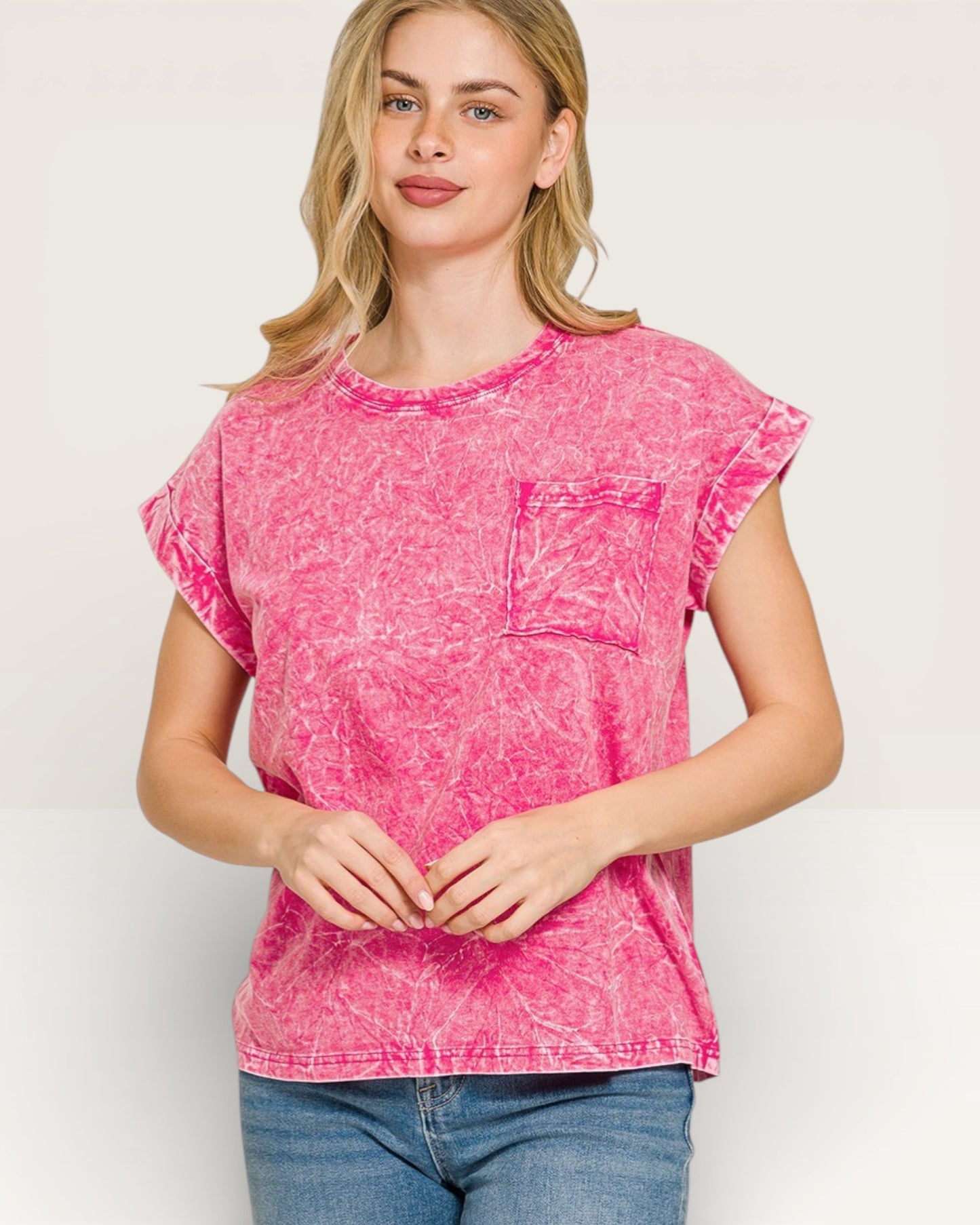 Woman wearing a pink acid-wash t-shirt on a white background
