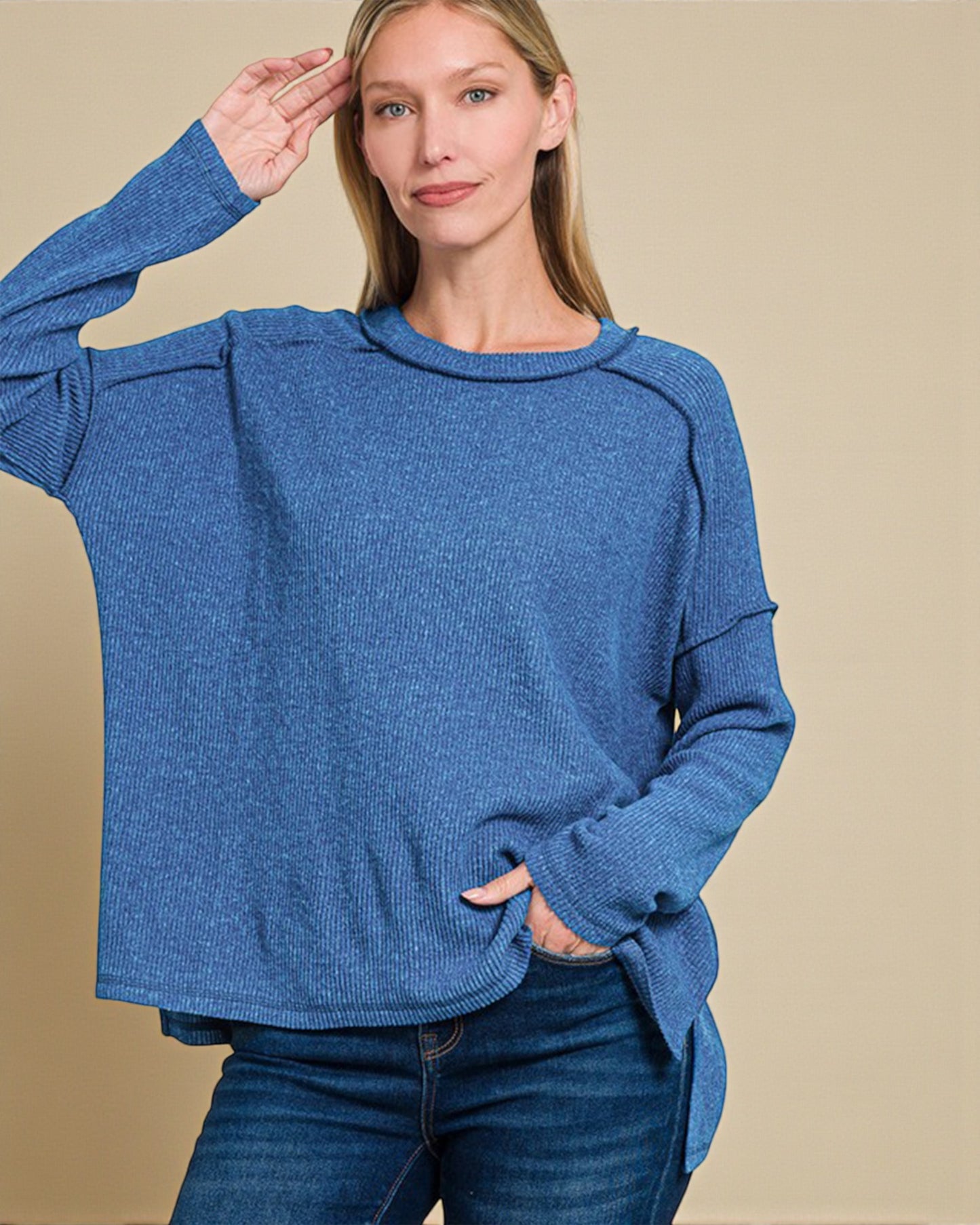 Woman wearing a blue sweater with a beige background