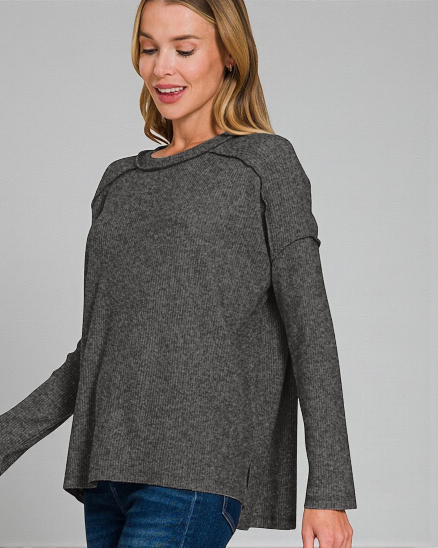 Woman wearing a gray sweater on a plain background
