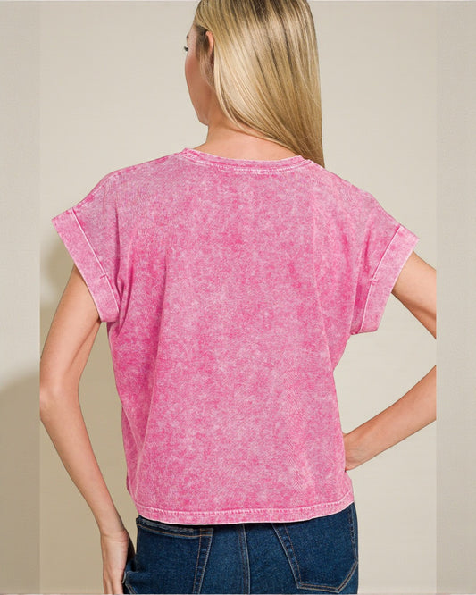 Person wearing a pink t-shirt with a plain background