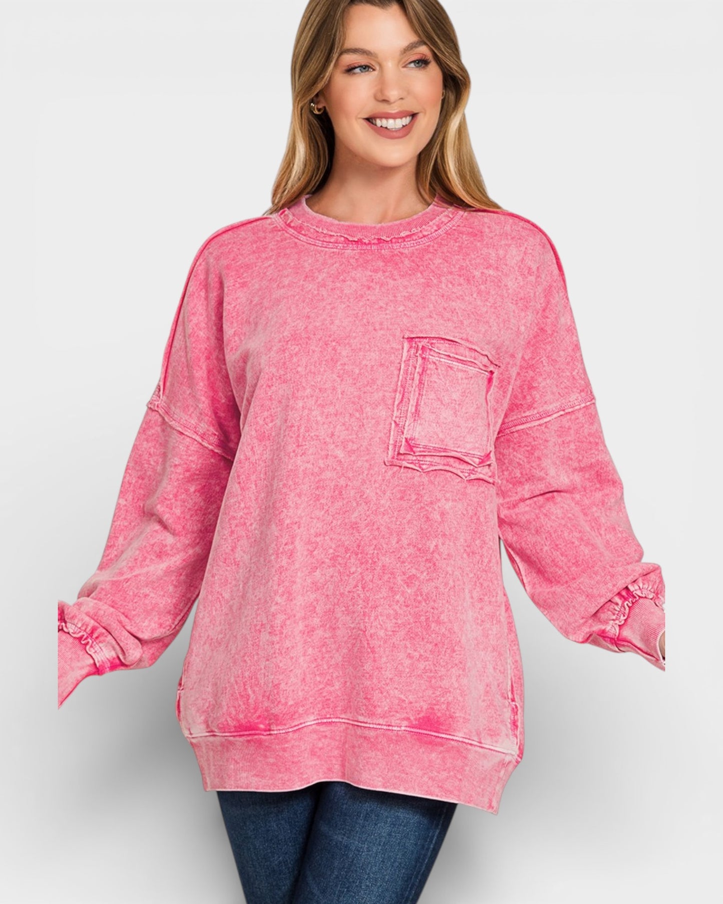 Woman wearing a pink acid-wash sweatshirt on a white background