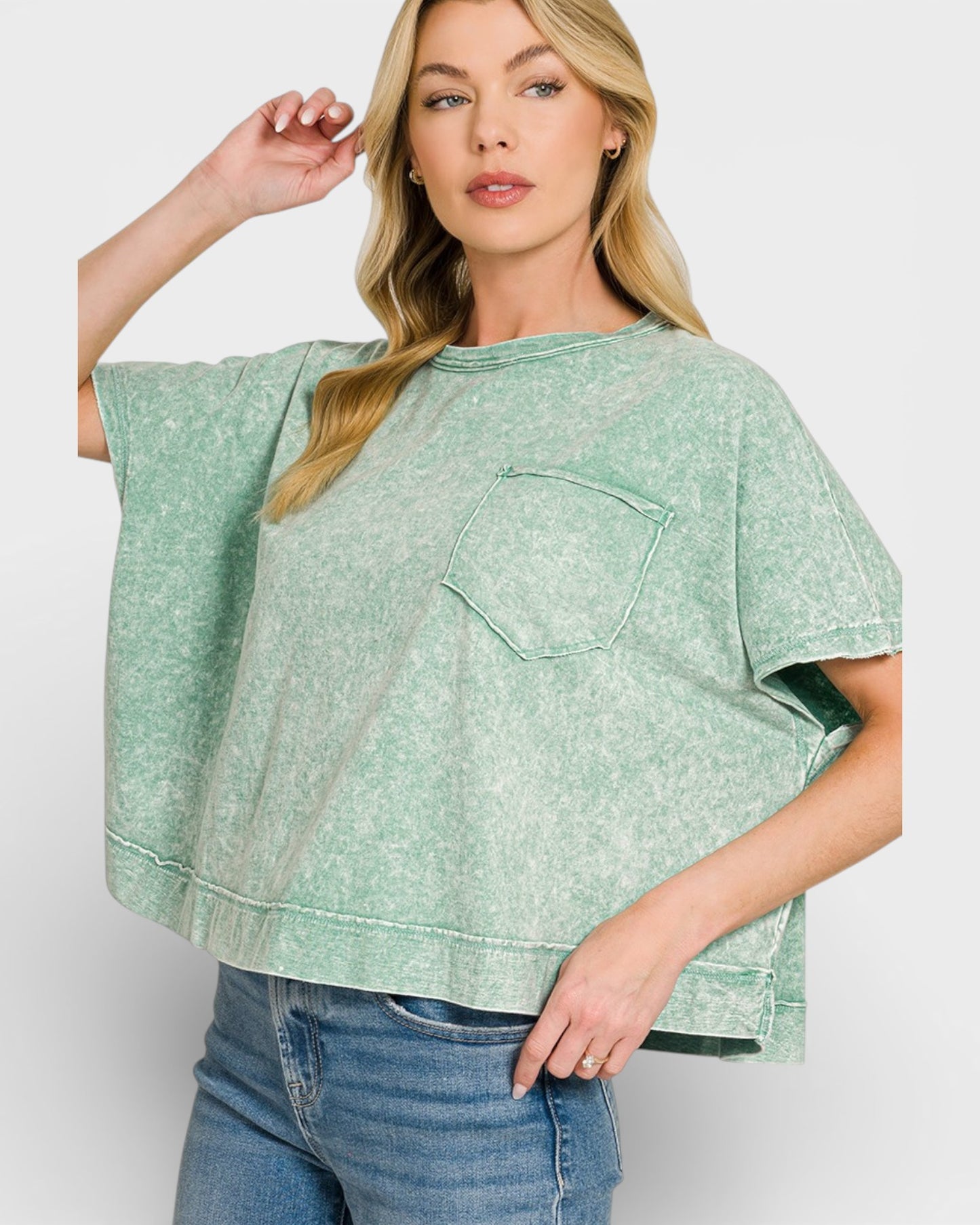 Woman wearing a green oversized shirt with a pocket on a white background