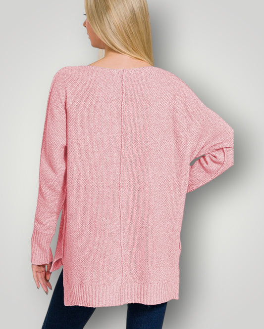 Person wearing a pink sweater against a plain background