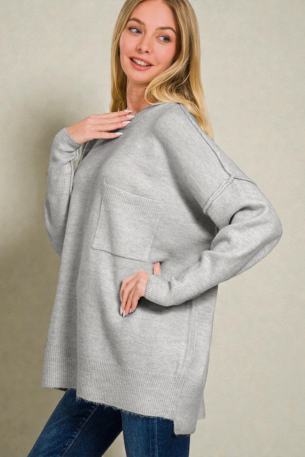 Woman wearing a gray sweater with a neutral background