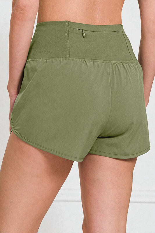 Green shorts worn by a person on a white background