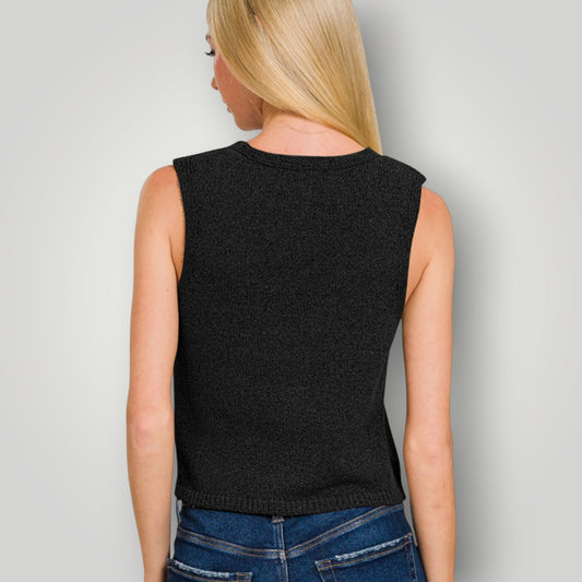 Person wearing a black sleeveless top and blue jeans against a plain background