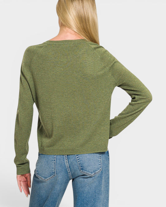 Person wearing a green sweater and blue jeans on a white background