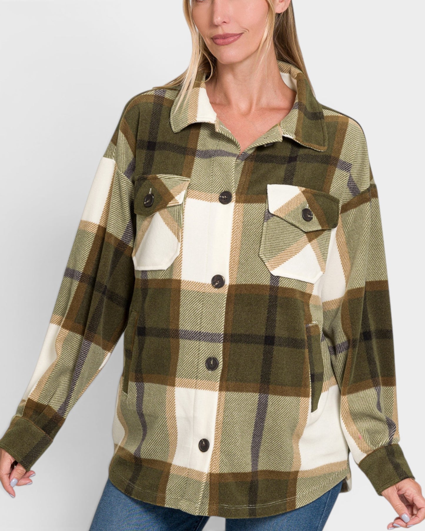 Person wearing a plaid shirt with green, brown, and white colors on a plain background