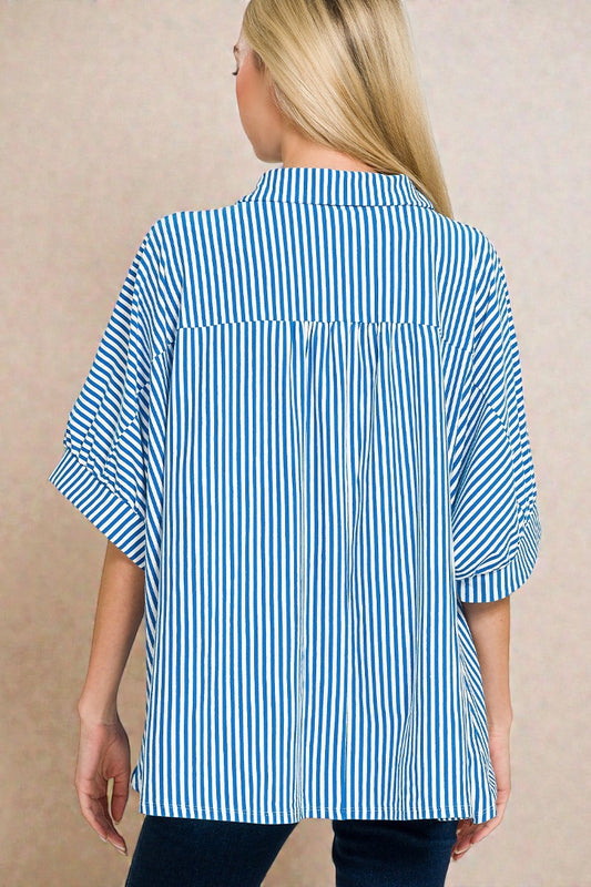 Woman wearing a blue and white striped shirt against a beige background