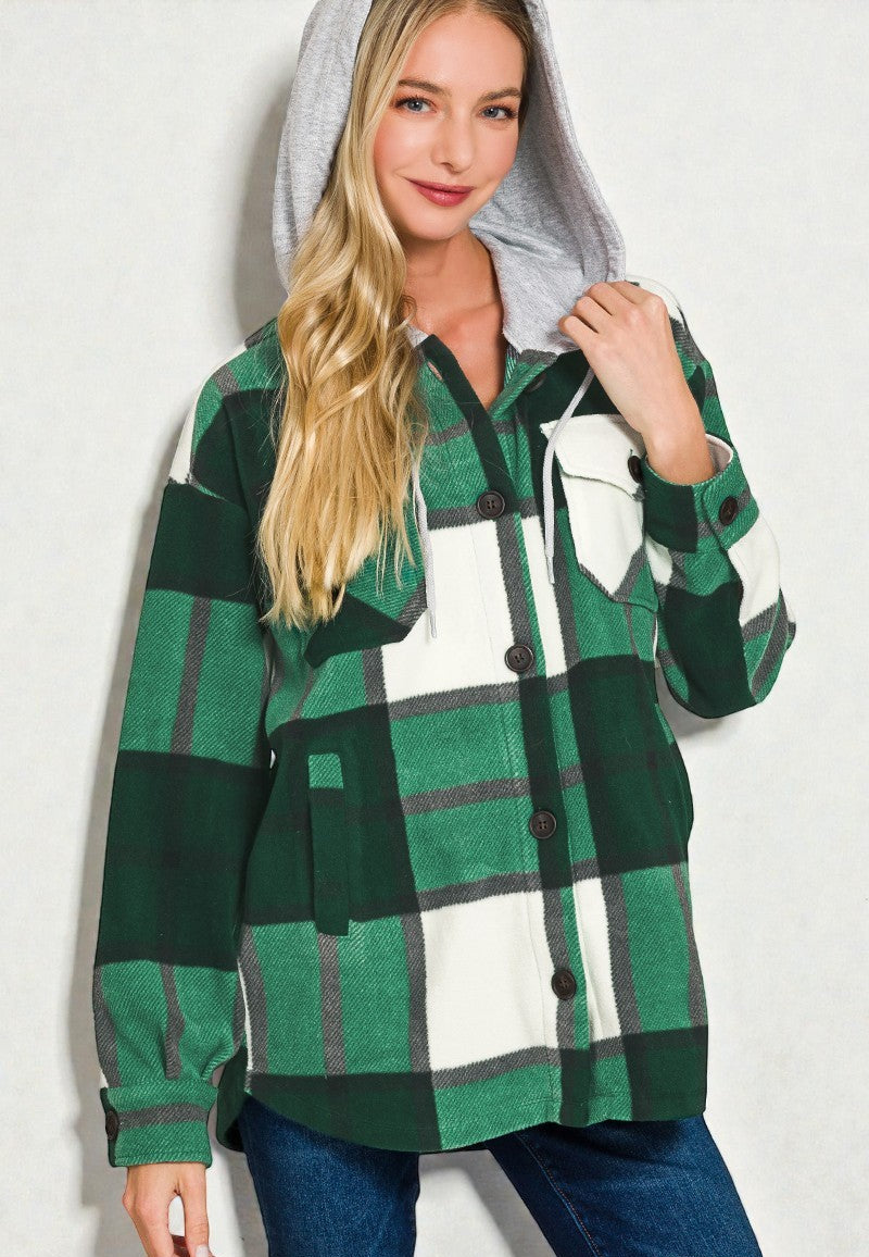 Woman wearing a green and white plaid shirt with a hood on a plain background