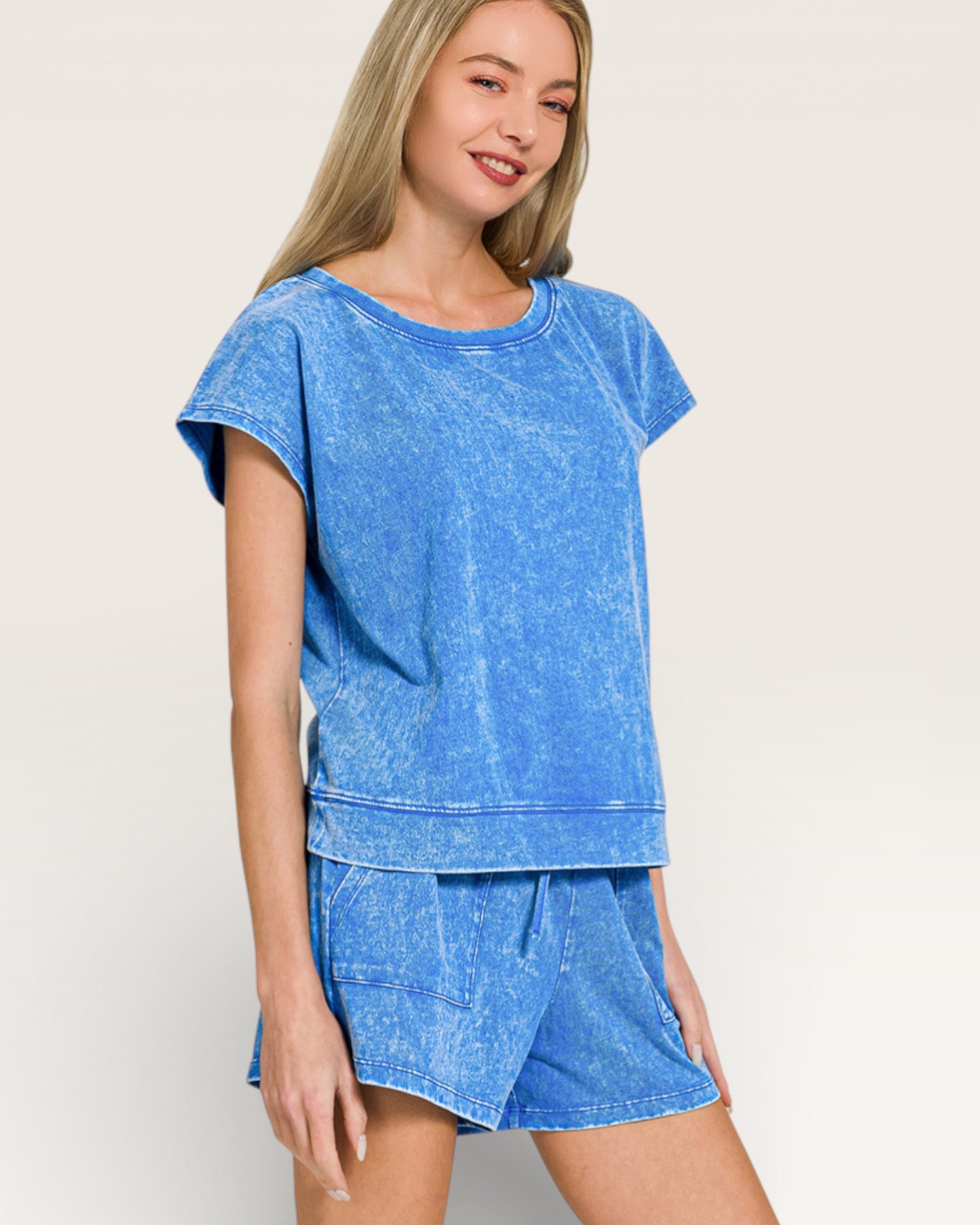 Woman wearing a blue denim outfit on a plain background